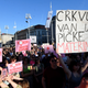 A woman holds a sign reading “The church out of the mother’s vagina” during the protest at the main square in Zagreb on May 12, 2022.